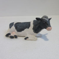 Lying black and white cow